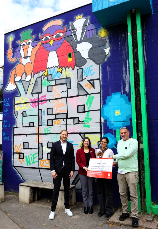 Spendenübergabe vor dem Wandbild, das Schülerinnen und Schüler der Waldparkschule gestaltet haben.