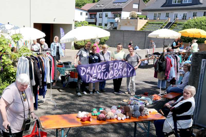 (hinter dem Banner, v.l.): Armin Wallnöfer, Heike Hauck, Griseldis Kumm, Judith Schwarz und Renate Deutschmann freuten sich gemeinsam über die rundum gelungene „Flohmarkt & Musik“-Premiere von „Dance für Democracy“ auf dem Boxberg.