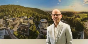 Damir Terzic ist der neue Hoteldirektor, hier vor einem Foto, das einen Teil der EMBL-Anlage zeigt.
