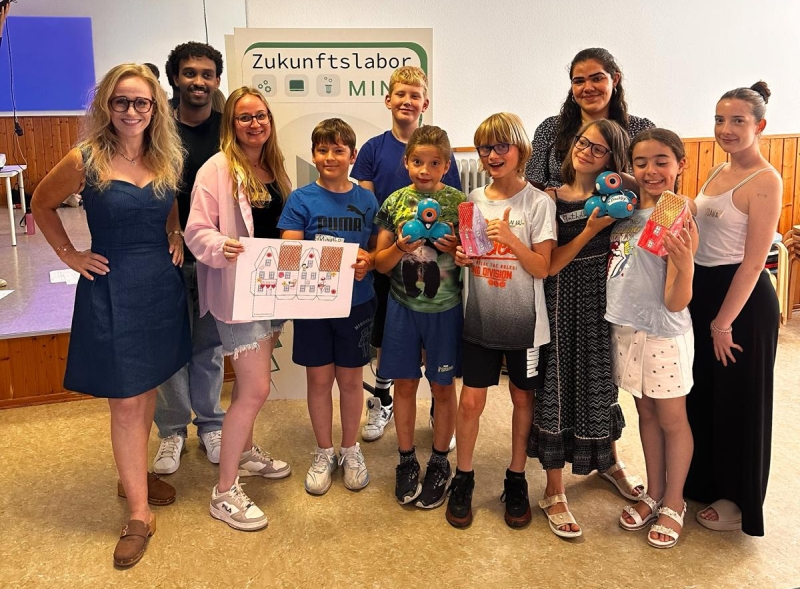 Bei herrlichem Sommerwetter draußen kreatives Schaffen drinnen. Links Projektleiterin Nicole Marmé, daneben der stellvertretende Kinderbeauftragte für den Emmertsgrund; Ahmed Abdulla