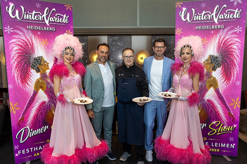 Las Vegas Showgirls des Wintervarietés umrahmen die beiden Geschäftsführer Riadh Bourkhis (l.) und Florian Keutel (r.). In der Mitte der neue Chefkoch Christian Adam. Foto: Cheesy/WinterVarieté